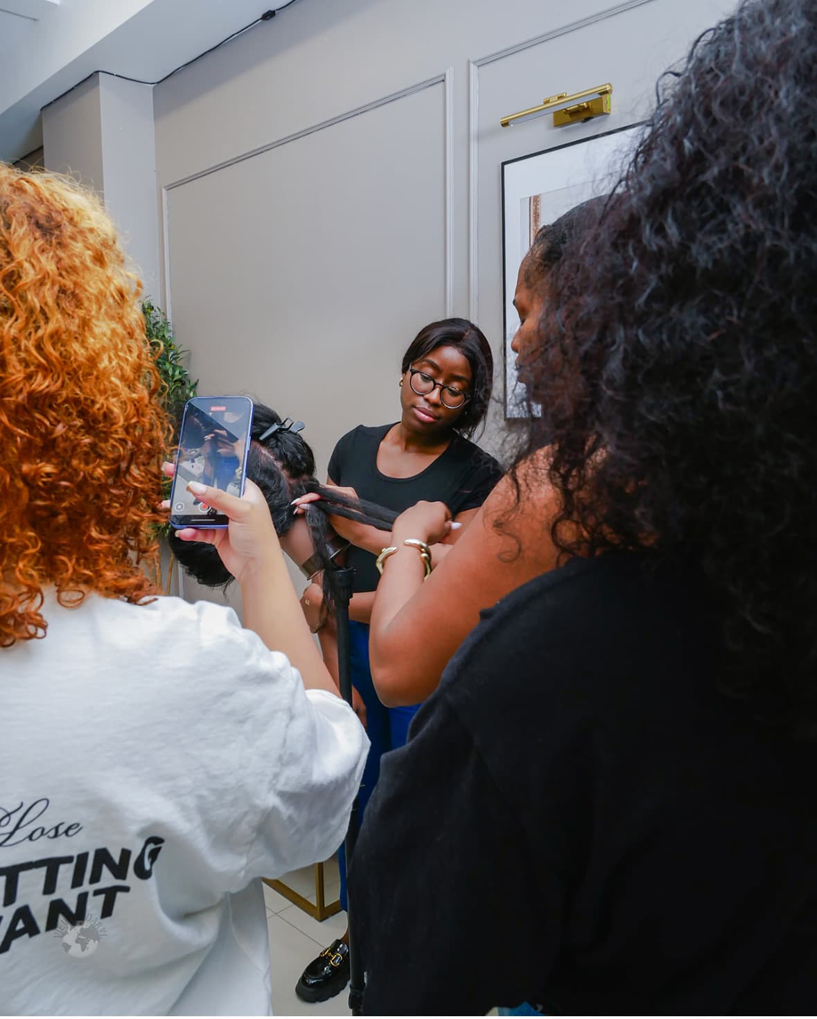 A student filming a close-up demonstration during a braiding class